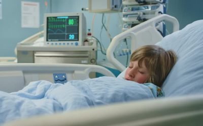 Handheld shot of ill boy sleeping on bed in ward. Child is resting in emergency room. He is at hospital.